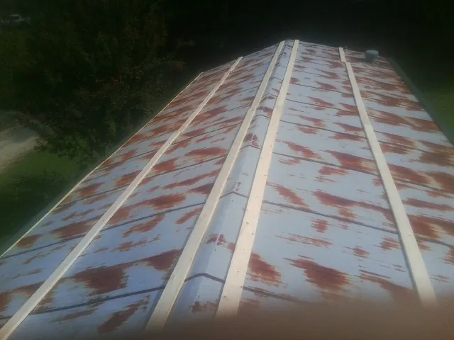 Rusted metal roof panels with new wood purlins before replacement — Storm Damage Roof Repair in Volant by Roofing Brothers