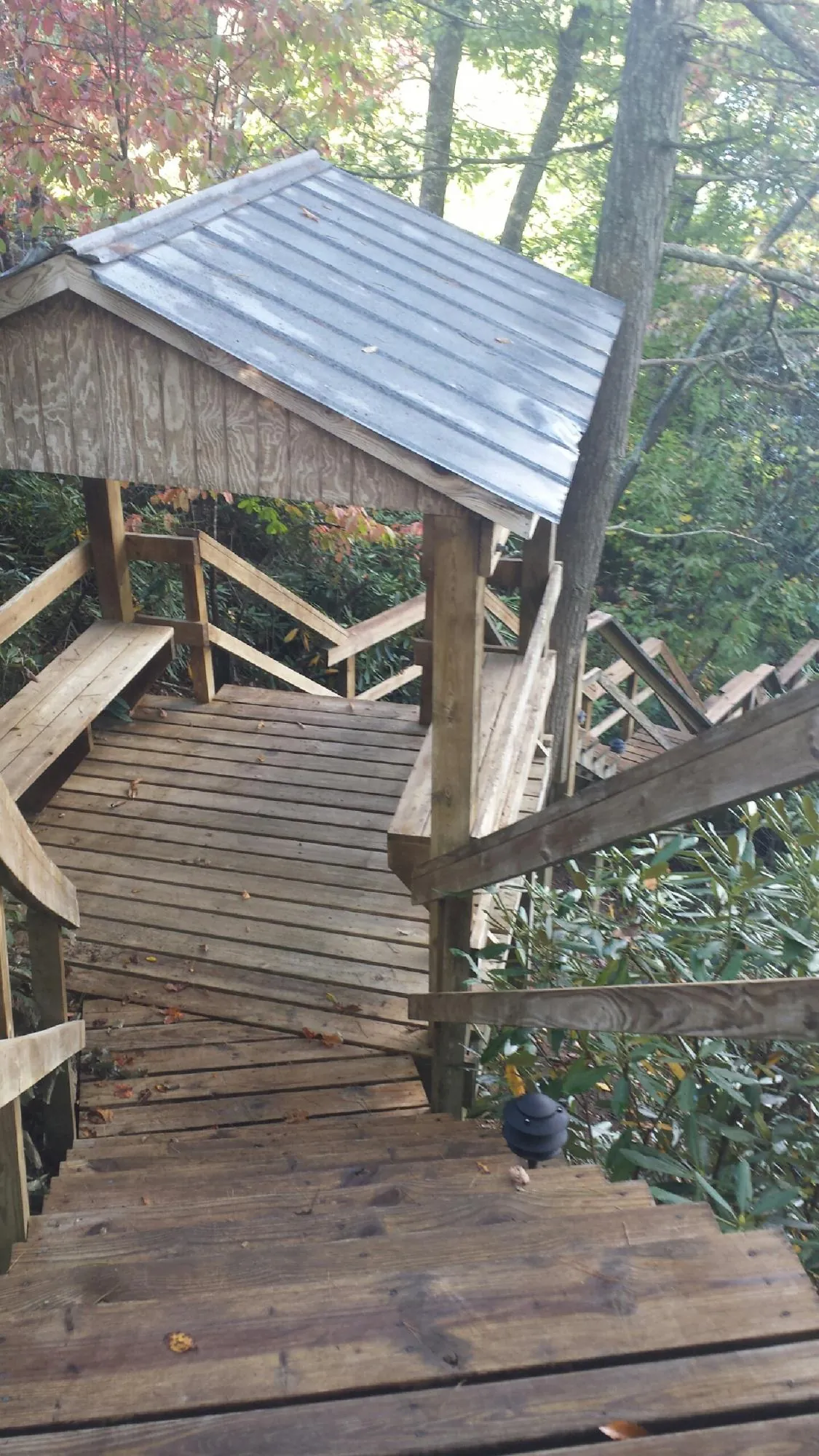 Metal roofed shelter over wooden steps on a wooded walkway — Skylight Repair & Installation work by our crew in Volant