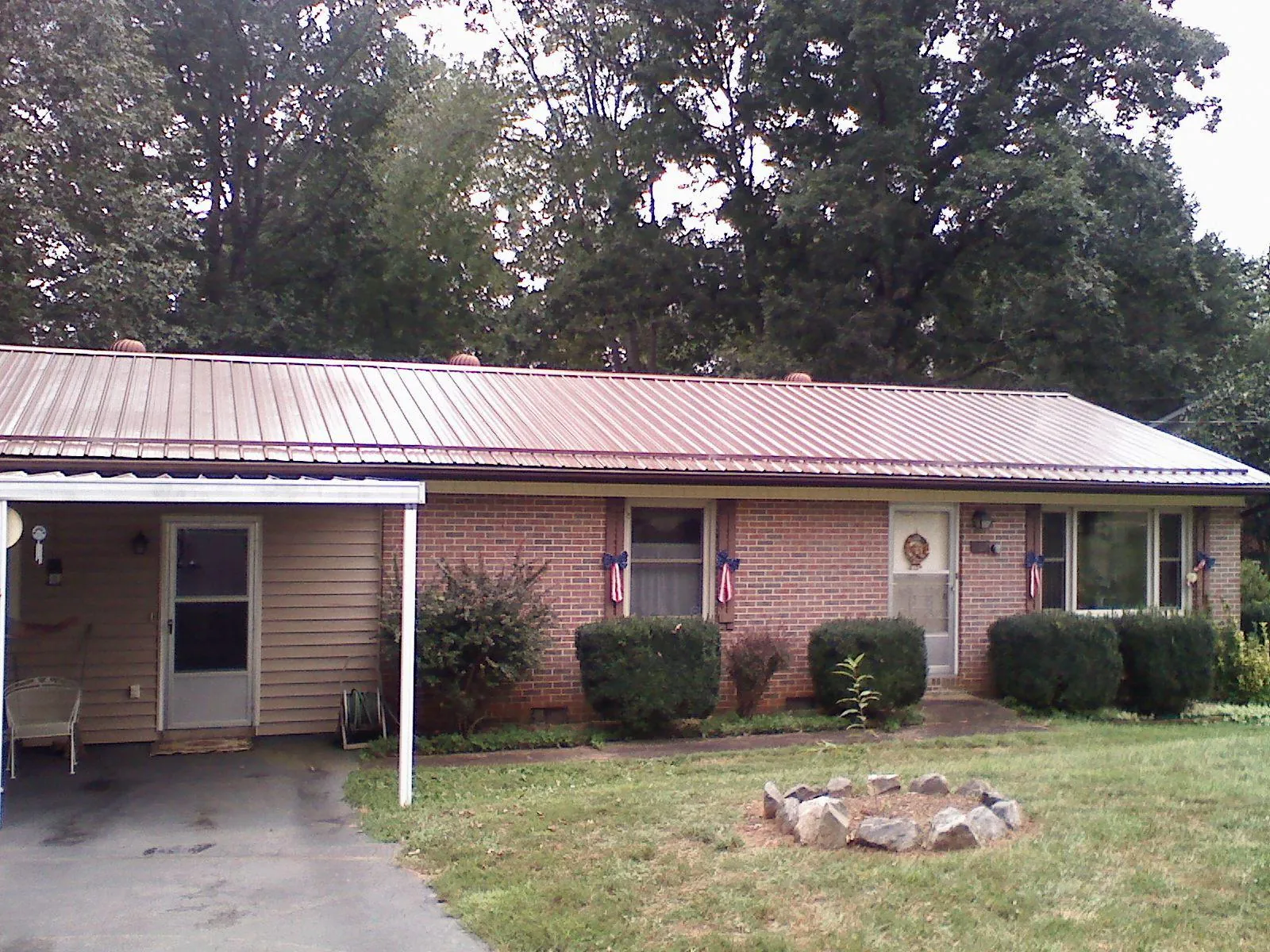 Bronze metal roof and carport on a brick ranch home — Roof Repair work by our crew in Volant