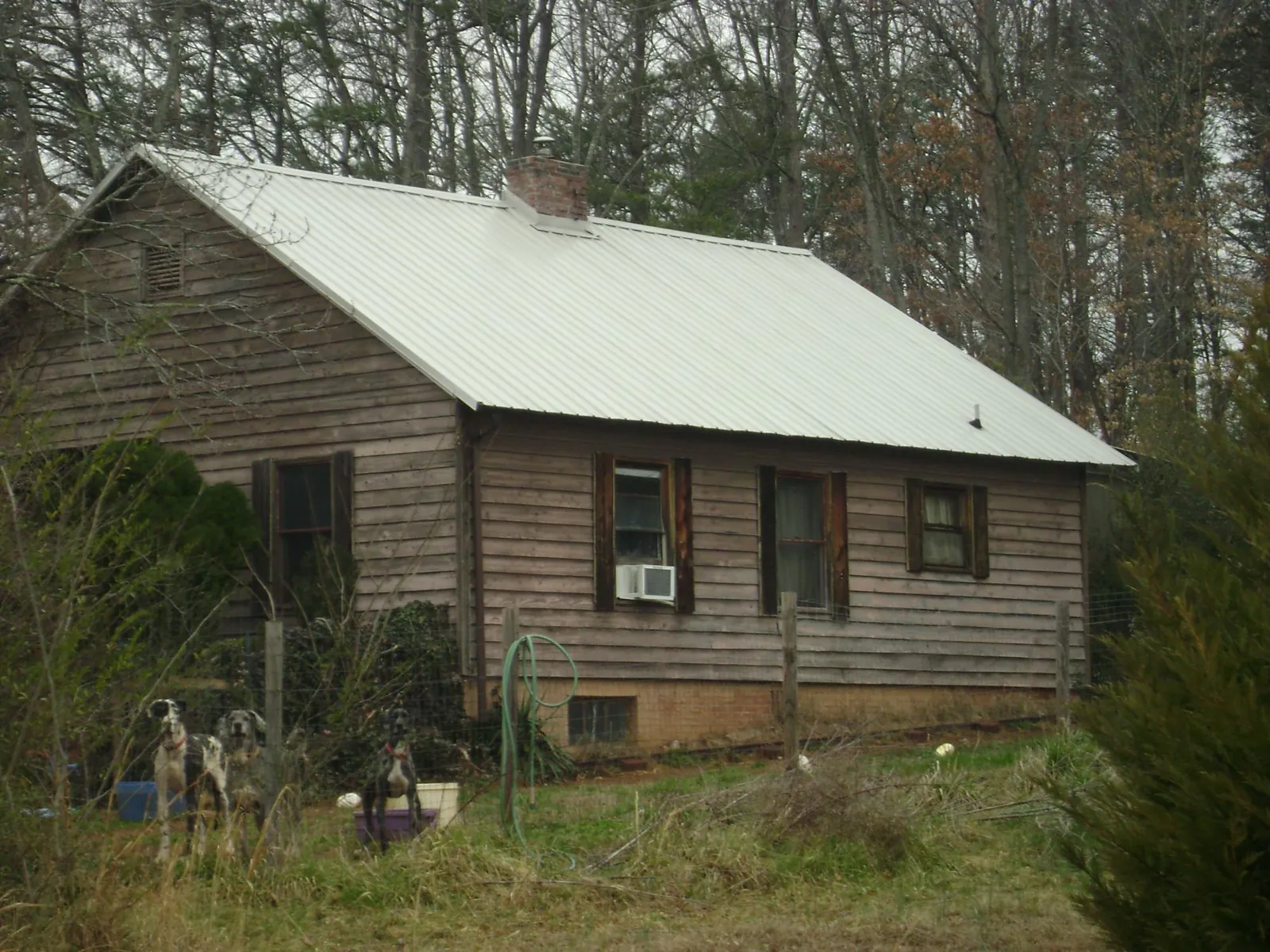 White metal roof on an old wood sided farmhouse, from a Metal Roof Installation job in Volant